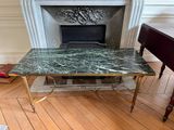 une table au plateau en marbre devant une cheminée