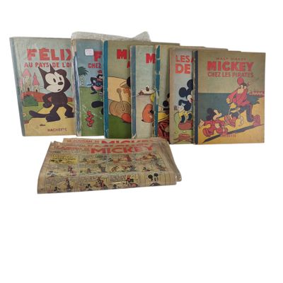 Des figurines de Mickey Mouse et des livres sur Mickey Mouse sont empilés les uns sur les autres