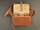 a brown leather bag with a pair of scissors in it