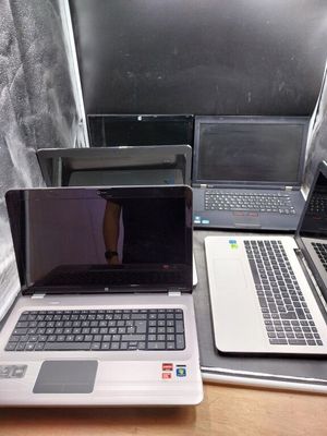three laptops are sitting on a table with one open and the other closed