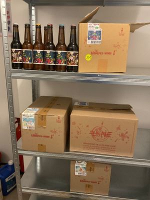 Des caisses de bière sont empilées sur une étagère dans une pièce