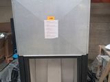 une photo d'un réfrigérateur dans un entrepôt où se trouvent de nombreux cartons