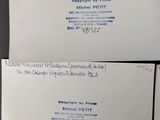 two white envelopes with blue writing on them sitting on a table