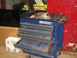 un chariot à outils bleu contenant des outils, dans un garage