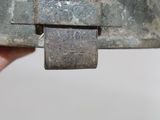 a person holding a piece of metal with a padlock on it