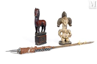 une statue en bois représentant un cheval et un couteau posés sur une table