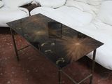 un canapé et une table dans une pièce où est accroché un tableau au mur