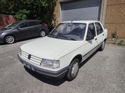 une voiture blanche garée dans un parking à côté d'un bâtiment