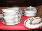 several plates and bowls are stacked on a red table cloth