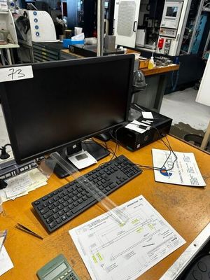 un bureau sur lequel se trouvent un ordinateur, un clavier, une souris et d'autres objets