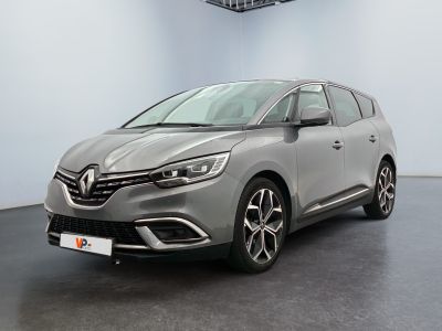 La voiture grise est garée dans une grande pièce équipée d'un ventilateur de plafond.