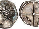 a close up of a coin with a face on it
