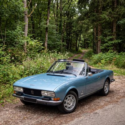 a blue convertible car parked on the side of the road
