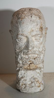 sculpture représentant la tête d'un homme barbu posée sur une table