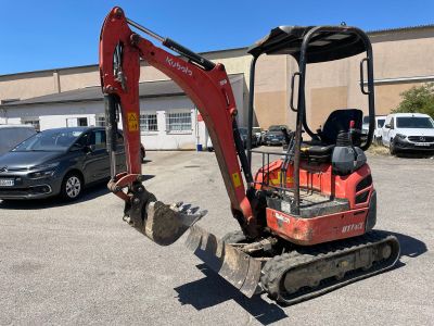 an image of a small excavator parked in a parking lot