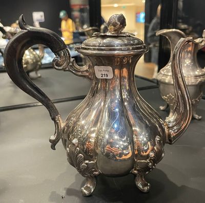 a silver tea pot sitting on a table in a room