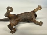 an old iron figurine of a cat laying on its back