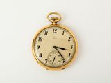 a gold pocket watch on a white surface