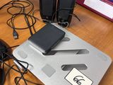 a desk with a laptop, mouse, and other electronics on it