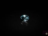 a close up of a blue diamond on a black surface
