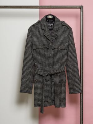 un manteau accroché à un porte-manteau devant un mur rose
