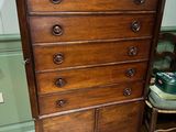 an old wooden dresser in a room with a chair
