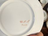 a person holding a white plate with a pink flower on it