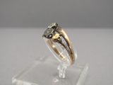 an image of a gold and silver ring on a clear stand