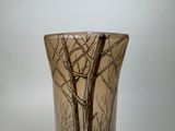 a vase with a tree design on it on a table