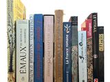 many books that are lined up together on a shelf