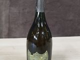 une vieille bouteille de champagne posée sur une table en bois, sur fond marron