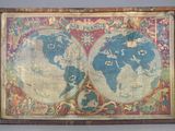 une vieille carte du monde dans un cadre en bois, posée sur une table