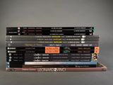 many books stacked on top of each other on a table