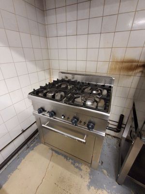 une cuisine sale avec une cuisinière et une plaque de cuisson