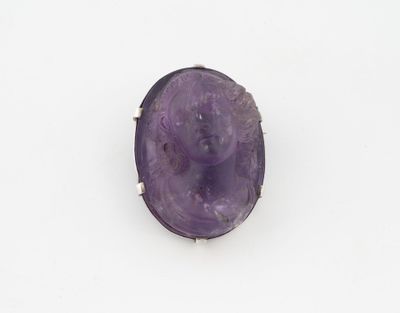 une image représentant une bague en pierre violette sur laquelle est gravé un visage