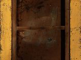 an old window with a rusted frame in the middle of a stone wall