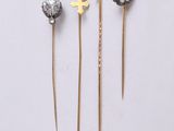 three gold and silver hair pins sitting on top of a white surface