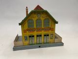 bâtiment jaune et vert surmonté d'une horloge au sommet du toit