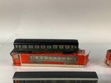 three toy trains sitting next to each other on a white surface