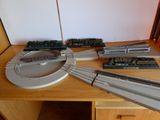 un circuit de trains miniatures posé sur une table à côté d'autres trains miniatures