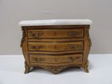 a small chest of drawers with a marble top
