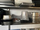 many trays and pans on the shelves in the kitchen
