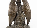 an image of a statue of an angel sitting on top of a rock