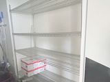 a room with shelves and a vacuum on the floor