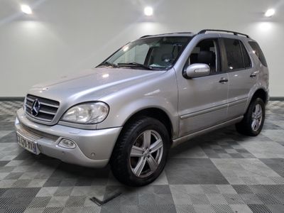 une photo d'un SUV Mercedes argenté garé sur un sol à damier
