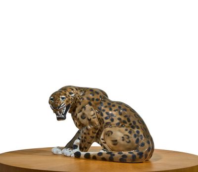 figurine of a leopard sitting on a round wooden table