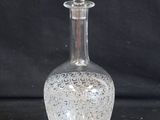 une bouteille en verre transparent avec un bouchon argenté