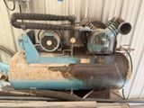 un vieux compresseur d'air posé sur un tas de bois