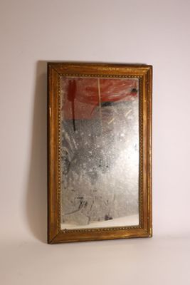 un miroir accroché au mur à côté d'un vase