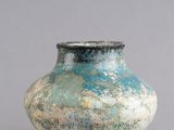 une image représentant un vase bleu et vert sur fond gris